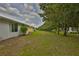View of home's backyard with well-maintained lawn and lush tree-lined property boundary at 2128 Worthington Greens Dr, Sun City Center, FL 33573