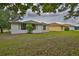 A view of the backyard with green grass and some trees around the house at 2128 Worthington Greens Dr, Sun City Center, FL 33573
