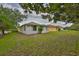 The backyard has grass and a few trees around the house at 2128 Worthington Greens Dr, Sun City Center, FL 33573