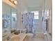 Bright bathroom featuring a shower-tub combo, white tiled walls, a vanity, and decorative blue seashell art at 2128 Worthington Greens Dr, Sun City Center, FL 33573