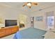Comfortable bedroom with tray ceiling, ceiling fan, and arched doorway to other rooms at 2128 Worthington Greens Dr, Sun City Center, FL 33573