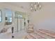 Bright bedroom with tile floors, chandelier lighting and decorative pillars at 2128 Worthington Greens Dr, Sun City Center, FL 33573