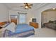 Cozy bedroom with tray ceiling, ceiling fan, and view into the adjacent bedroom at 2128 Worthington Greens Dr, Sun City Center, FL 33573