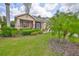 Charming home with lush landscaping, a cozy screened porch, and well-maintained lawn at 2128 Worthington Greens Dr, Sun City Center, FL 33573