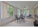 Bright sunroom featuring large windows, tile floors, and a ceiling fan, perfect for relaxation and entertaining at 2128 Worthington Greens Dr, Sun City Center, FL 33573