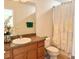 Bathroom with granite countertops, decorative sink, shower and toilet featuring a floral curtain at 2130 Broadway View Ave, Brandon, FL 33510