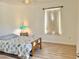 Bright bedroom with hardwood floors, a twin bed, a lamp on the bedside table, and a sunlit window at 2130 Broadway View Ave, Brandon, FL 33510
