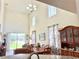 Open-concept dining room featuring soaring ceilings, a large window, and a classic wooden hutch, adjoining the living area at 2130 Broadway View Ave, Brandon, FL 33510