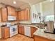 Functional kitchen with a microwave, wooden cabinets, stainless steel sink, granite countertops, and modern appliances at 2130 Broadway View Ave, Brandon, FL 33510