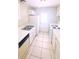 Galley kitchen features white appliances, tiled floors, ample counter space, and access to the exterior at 2302 Maki Rd # 69, Plant City, FL 33563