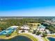 Panoramic aerial view of community amenities featuring a pool, tennis courts, and lush landscaping surrounded by nature at 2424 Caraway Dr, Venice, FL 34292
