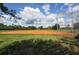 Well-maintained baseball field with orange clay base paths and green grass, ready for play at 2424 Caraway Dr, Venice, FL 34292