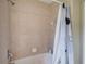 Cozy bathroom with a neutral tile surround, shower, and tub, complemented by a clean white shower curtain at 2424 Caraway Dr, Venice, FL 34292