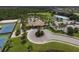 Aerial view of the community clubhouse and pool area, showing tennis courts and surrounding landscaping at 2424 Caraway Dr, Venice, FL 34292
