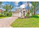 Inviting two-story home boasting a well-kept lawn, brick driveway, lush landscaping, and a two-car garage at 2424 Caraway Dr, Venice, FL 34292