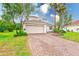 Charming two-story home showcasing a well-manicured front yard, a two-car garage, and a brick driveway at 2424 Caraway Dr, Venice, FL 34292