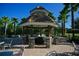 Community center's outdoor gazebo featuring brick flooring, stone accents, and nearby palm trees at 2424 Caraway Dr, Venice, FL 34292