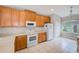 Bright kitchen with wooden cabinets, white appliances, and tile flooring at 2424 Caraway Dr, Venice, FL 34292