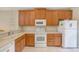 Well-lit kitchen with wooden cabinetry, appliances, and light countertops offering lots of potential at 2424 Caraway Dr, Venice, FL 34292