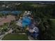 Aerial view of a resort-style pool and lounge area surrounded by lush landscaping and palm trees at 2424 Caraway Dr, Venice, FL 34292