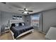 This primary bedroom boasts a ceiling fan, artwork, and large window with natural light at 2435 Edgewater Falls Dr, Brandon, FL 33511