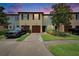 Inviting townhome featuring colorful exterior, a single-car garage, well-kept lawn, and a paved driveway at 2435 Edgewater Falls Dr, Brandon, FL 33511