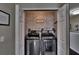 Laundry closet features brick accent wall, modern washer, dryer, and laundry-themed décor at 2435 Edgewater Falls Dr, Brandon, FL 33511