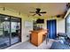Covered patio featuring a custom wooden bar, stools, and a mounted flat-screen TV at 2435 Edgewater Falls Dr, Brandon, FL 33511
