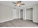 Bright bedroom featuring gray wood floors, ceiling fan, and large double closets at 24862 Us Highway 19 N # 1105, Clearwater, FL 33763