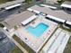 Aerial view of a fenced community pool with surrounding lounge chairs and umbrellas at 24862 Us Highway 19 N # 1105, Clearwater, FL 33763