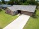 Aerial view of a well-maintained home with a long driveway, two-car garage and mature landscaping at 2608 Camille Dr, Palm Harbor, FL 34684