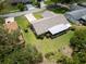 Aerial view of a well-maintained home with a screened lanai and a spacious green lawn in a residential neighborhood at 2608 Camille Dr, Palm Harbor, FL 34684