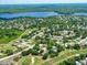 Expansive aerial shot of the community, highlighting the lake, golf course, and residential homes amid lush greenery at 2608 Camille Dr, Palm Harbor, FL 34684