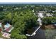 Aerial view of the lake community with a dock, recreational amenities, and lush trees for outdoor enjoyment at 2608 Camille Dr, Palm Harbor, FL 34684