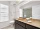Bright bathroom featuring a vanity with a tan countertop and a framed mirror with vanity lights at 2608 Camille Dr, Palm Harbor, FL 34684