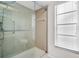 This tiled shower stall features glass doors, a shower head, and an adjustable shower handle at 2608 Camille Dr, Palm Harbor, FL 34684