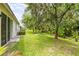 Spacious backyard featuring lush landscaping, green grass, and an open lawn at 27353 Edenfield Dr, Wesley Chapel, FL 33544