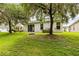 Lush backyard with mature trees and a designated fire pit area at 27353 Edenfield Dr, Wesley Chapel, FL 33544