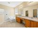 Well-lit bathroom with dual sinks, a soaking tub, and a separate tiled shower enhancing comfort and convenience at 27353 Edenfield Dr, Wesley Chapel, FL 33544
