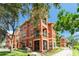 Attractive three-story building featuring stucco walls, balcony, and manicured landscaping at 2741 Via Cipriani # 934B, Clearwater, FL 33764