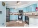 The kitchen boasts blue cabinets, stainless steel appliances, a stylish backsplash, and wood floors at 2741 Via Cipriani # 934B, Clearwater, FL 33764