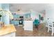 Open-concept kitchen with bar seating features blue cabinets, wood floors, and modern appliances at 2741 Via Cipriani # 934B, Clearwater, FL 33764