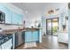 The kitchen provides blue cabinets, stainless appliances, and sliding door access to an outdoor deck at 2741 Via Cipriani # 934B, Clearwater, FL 33764