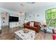 Bright living room with wood floors, stylish decor, and modern TV setup at 2741 Via Cipriani # 934B, Clearwater, FL 33764