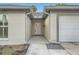 Covered front entry with a decorative stone detail, neutral paint, and white front door at 3058 Cara Ct, Palm Harbor, FL 34684