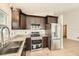 Contemporary kitchen boasts stainless steel appliances, granite counters, and dark wood cabinetry at 3058 Cara Ct, Palm Harbor, FL 34684