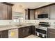 Well-lit kitchen with stainless steel appliances, granite countertops and rich dark wood cabinets at 3058 Cara Ct, Palm Harbor, FL 34684