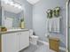 Well-lit bathroom featuring gray walls, a white vanity with storage, and decorative wall accents at 311 1St Sw Ave, Largo, FL 33770