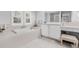 Bright bathroom featuring a soaking tub, tile floors, plantation shutters, and vanity with ample storage at 311 1St Sw Ave, Largo, FL 33770