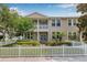Inviting townhouse with a covered porch, balcony, and a charming white picket fence at 311 1St Sw Ave, Largo, FL 33770